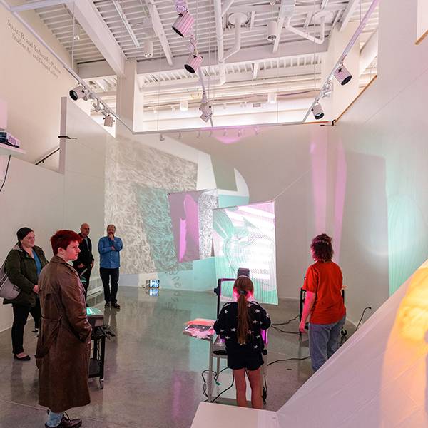 MAEA Image Studio Exhibition showing people in the gallery space and brightly colored projections